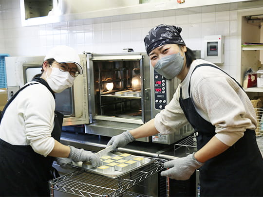 笑顔でパイナップルクッキーを焼く、ワーカーさん